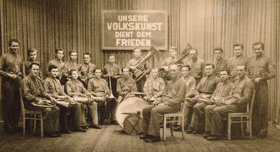 Das älteste Bild des Blasorchesters von 1951. Es zeigt: Schnell gehörten mehr als 12 Mitglieder zum Ensemble. Damaliger Leiter war Herrmann Czimmek (Mitte). Er wurde 1953 von Walter Schugardt abgelöst, der das Orchester bis 1978 leitete.
